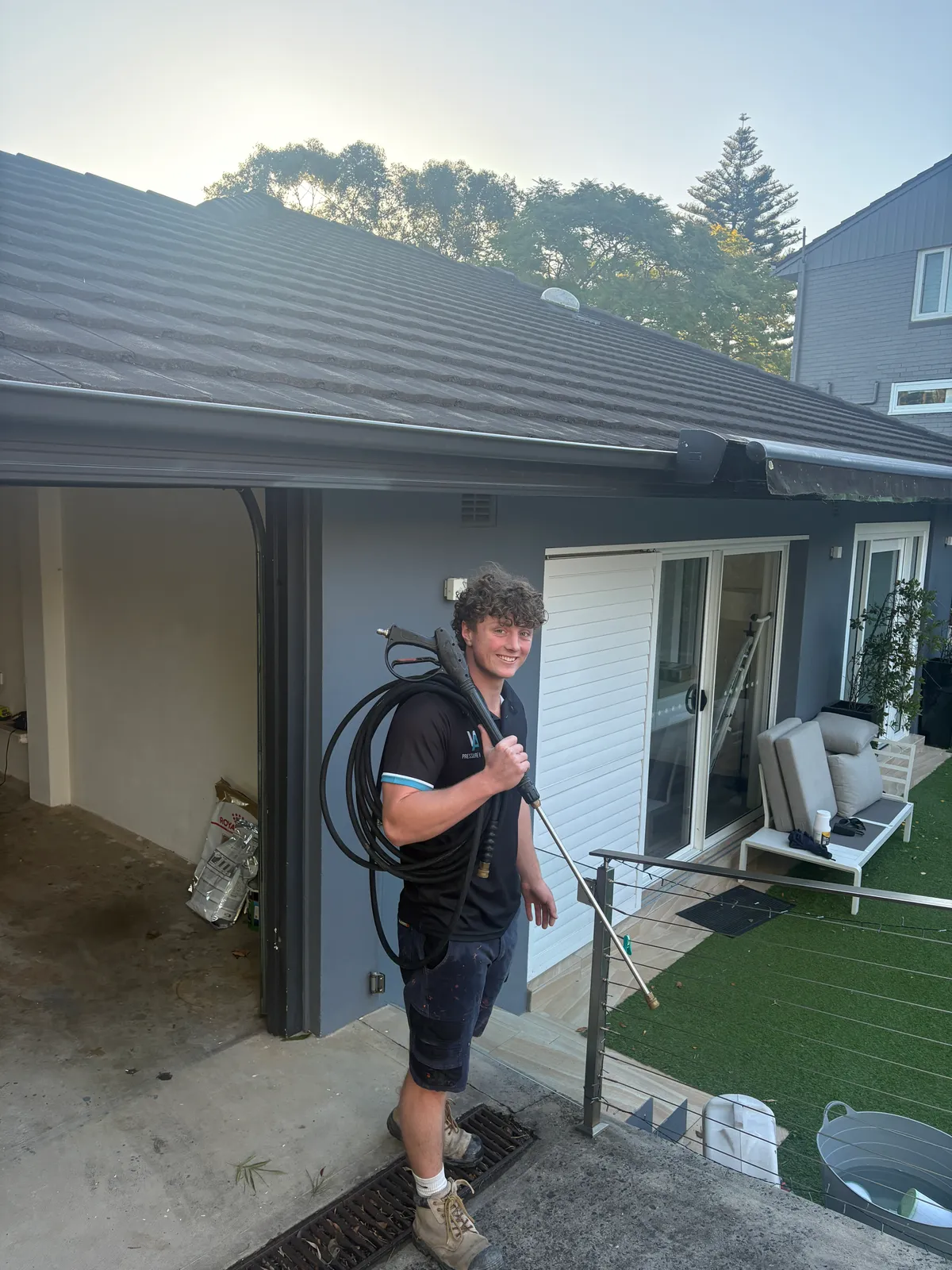 Alfie Wragge, founder of AW Pressure Washing, on a job in Sydney with hose and pressure wand