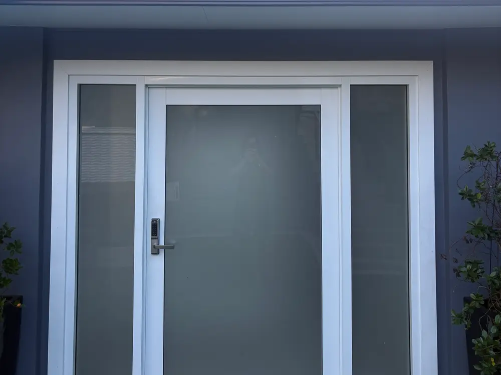 Freshly washed rendered entry and glass front door