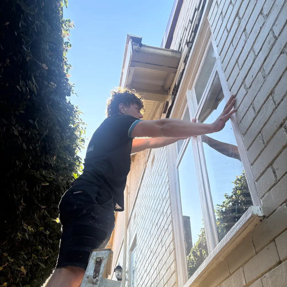 AW technician applying SpotBlock Tech protective treatment to upper window glass