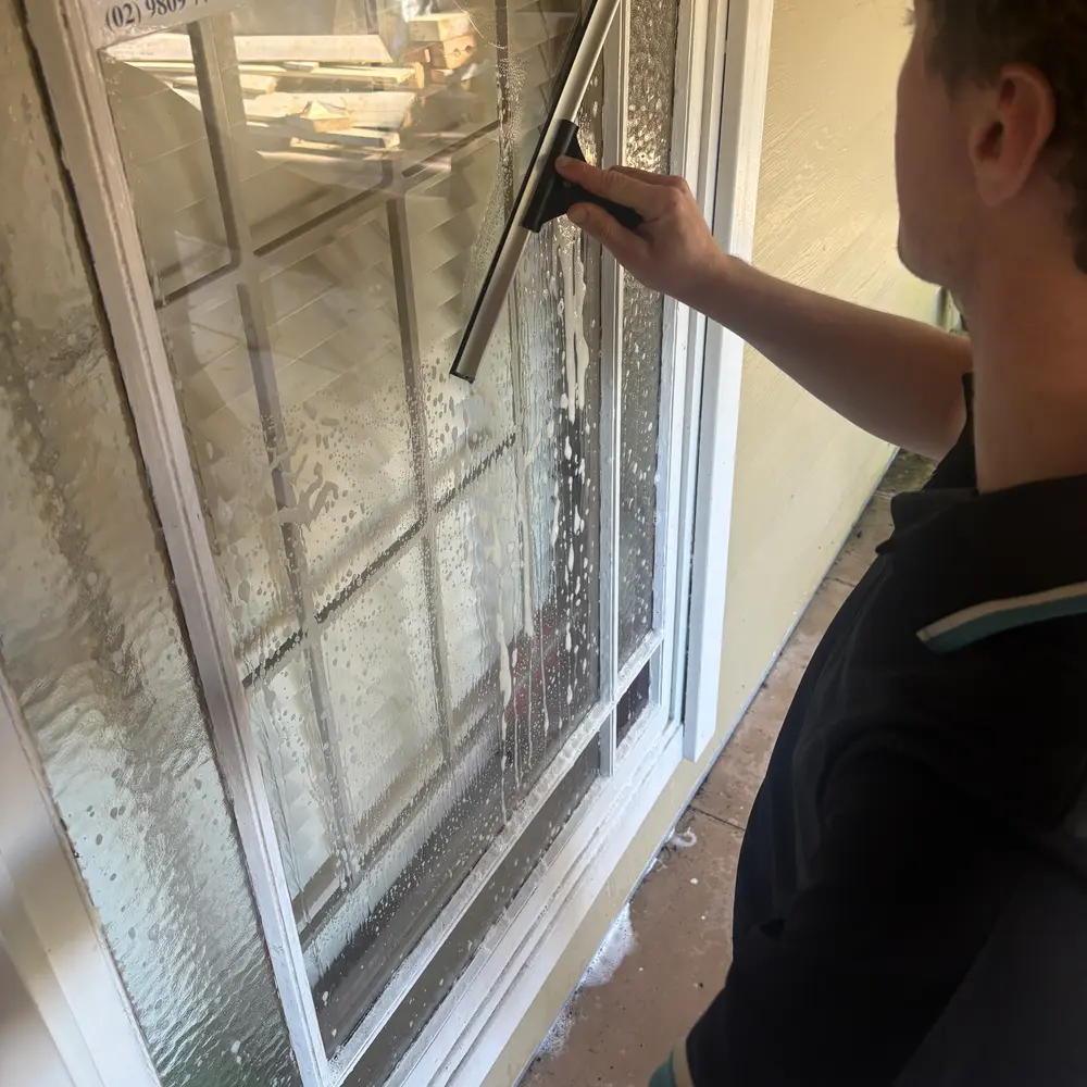 AW technician squeegeeing a window to a streak-free finish
