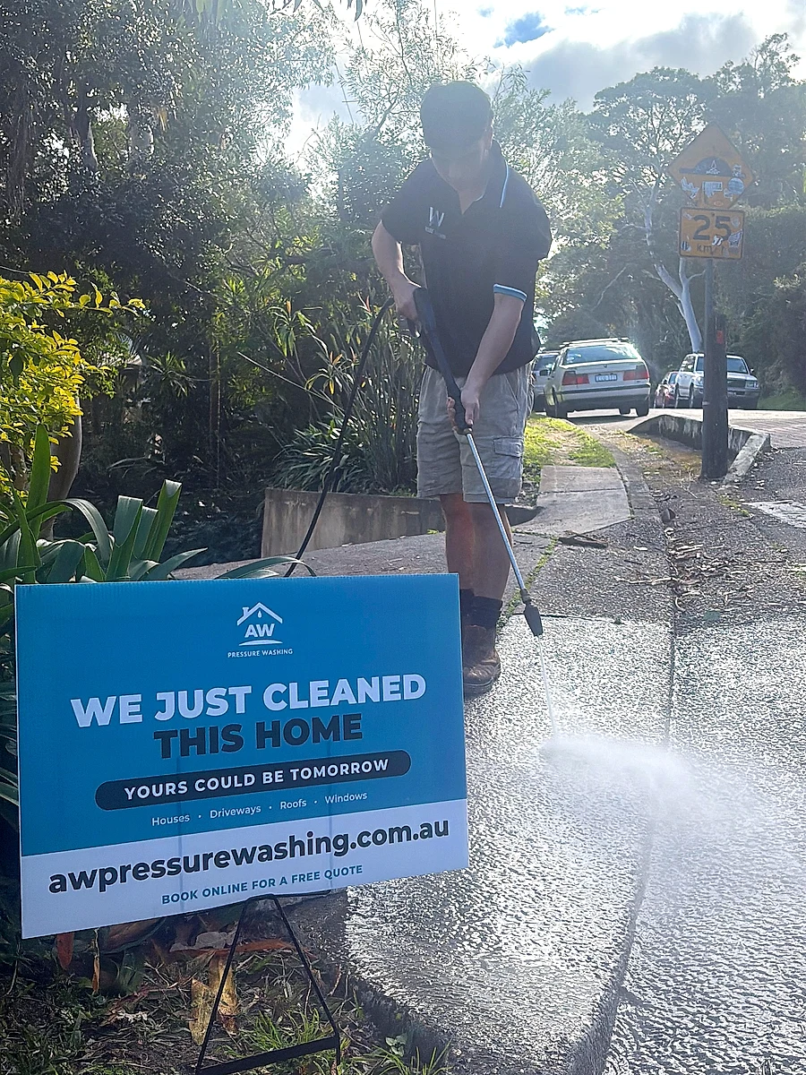 AW Pressure Washing yard sign reading We just cleaned this home, with the footpath being pressure washed behind it