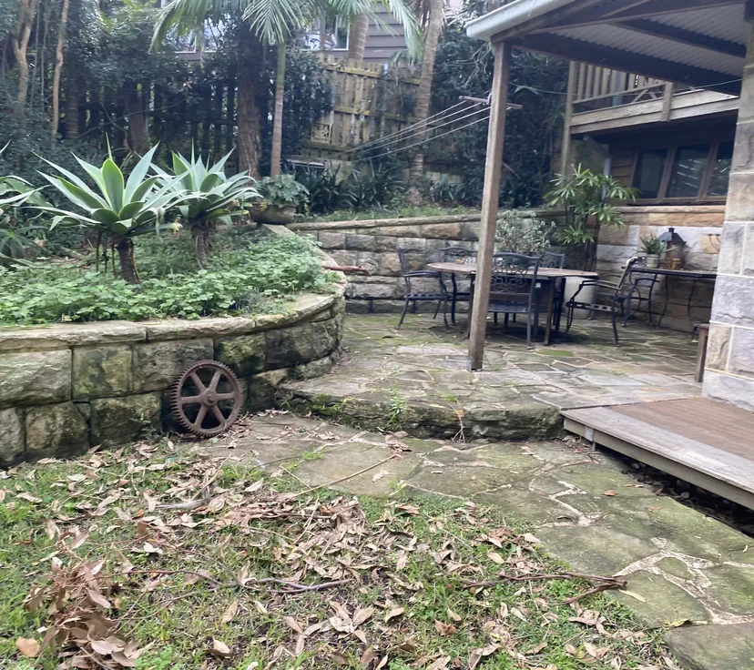 Sandstone courtyard before cleaning, dark with moss and algae