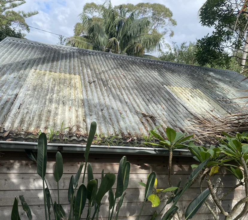 Corrugated metal roof with moss and grime, before cleaning
