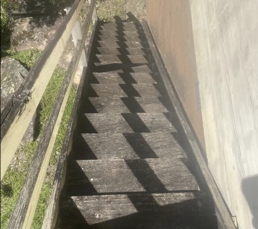 Timber staircase before cleaning, treads blackened with years of grime
